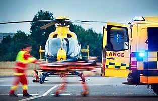 man being rushed to ambulance