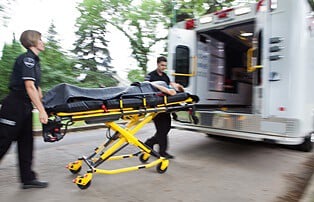 woman being rushed to ambulance